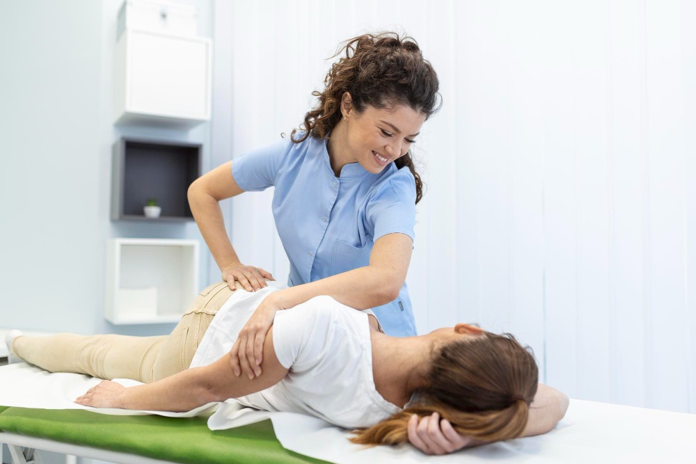 Physical therapist providing minimally invasive back pain treatment to an active adult patient during recovery therapy